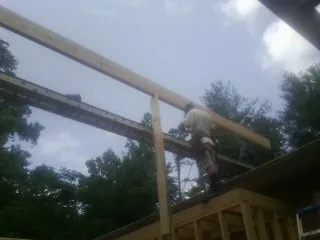 Carpenter setting a ridge beam over a new addition frame — Ice Dam Removal by Roofing Brothers in Galesville