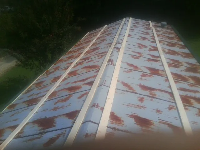 Rusted metal roof panels with new wood purlins before replacement — Storm Damage Roof Repair in Galesville by Roofing Brothers