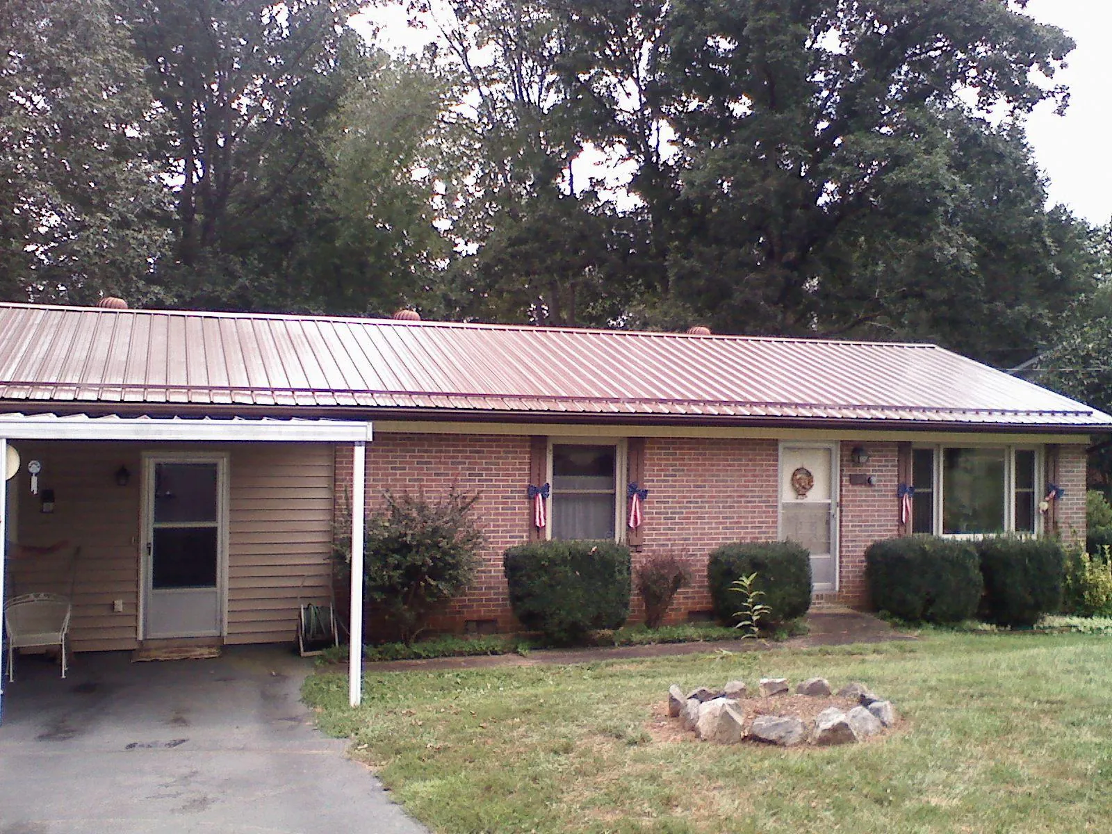 Bronze metal roof and carport on a brick ranch home — Roof Repair work by our crew in Galesville